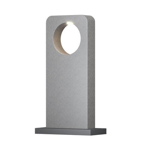 Maytoni Betone LED bollard light in cement finish with tall rectangular column, circular aperture housing a warm white LED, on a grey base.