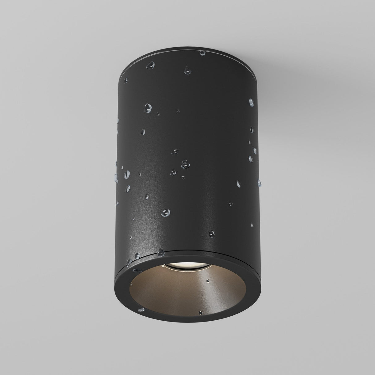 The Zoom Small Round Surface Downlight in matte black, featuring a metallic interior and water droplet texture, elegantly mounts against a plain white ceiling with an IP65 rating.