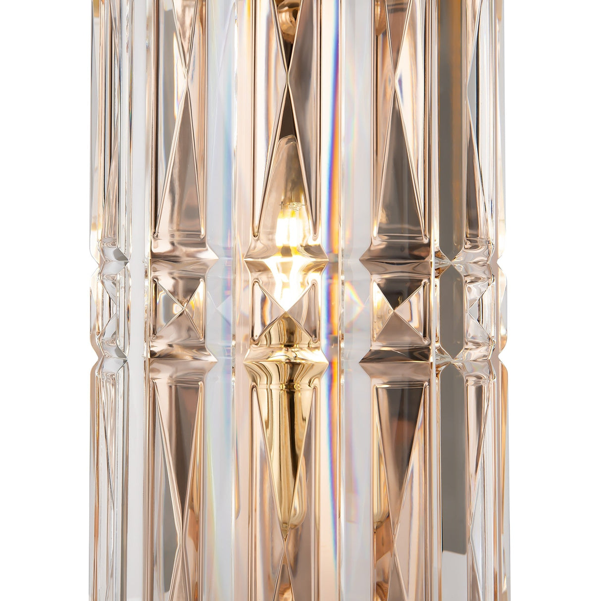 Close-up of the Facet Wall Light - Gold, featuring geometric patterns. Light beautifully reflects through clear and amber crystal faces, with a warm bulb glow enhancing its intricate design and gold finish adding elegance.