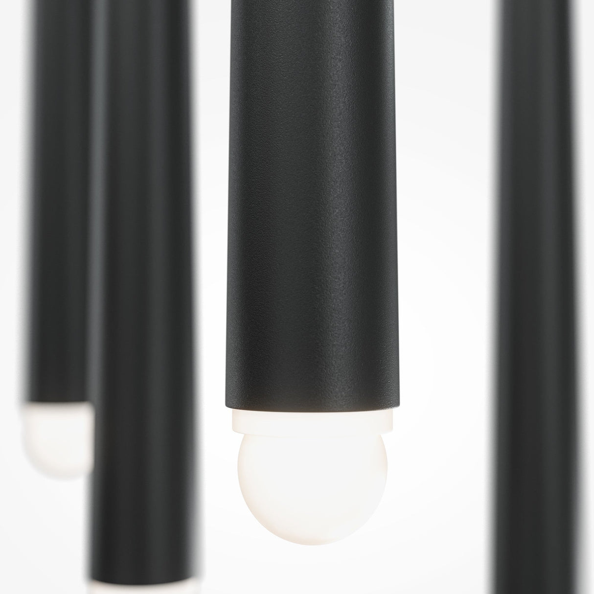Close-up of the Cascade CCT Dimmable LED Cluster Pendant Light (31W 3000-4000K - Black) with a sleek cylindrical black casing and glowing white bulb. The row of dimmable fixtures against a white background creates an elegant minimalist appearance.
