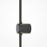 Close-up of the Light Stick LED Wall Light, a modern cylindrical fixture with a matte black finish. It emits 3000K warm light and features a vertical rod through its center, contrasting against the light gray background. Mounted horizontally for ambient illumination.