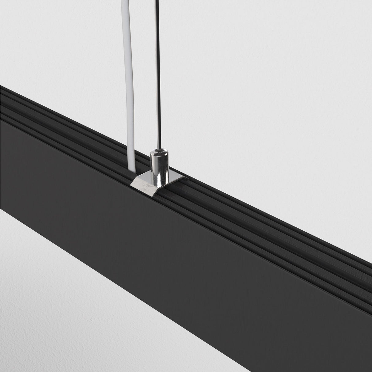 Close-up of the BASIS LED Linear Suspension Light's black finish, emphasizing its sophisticated aesthetic.