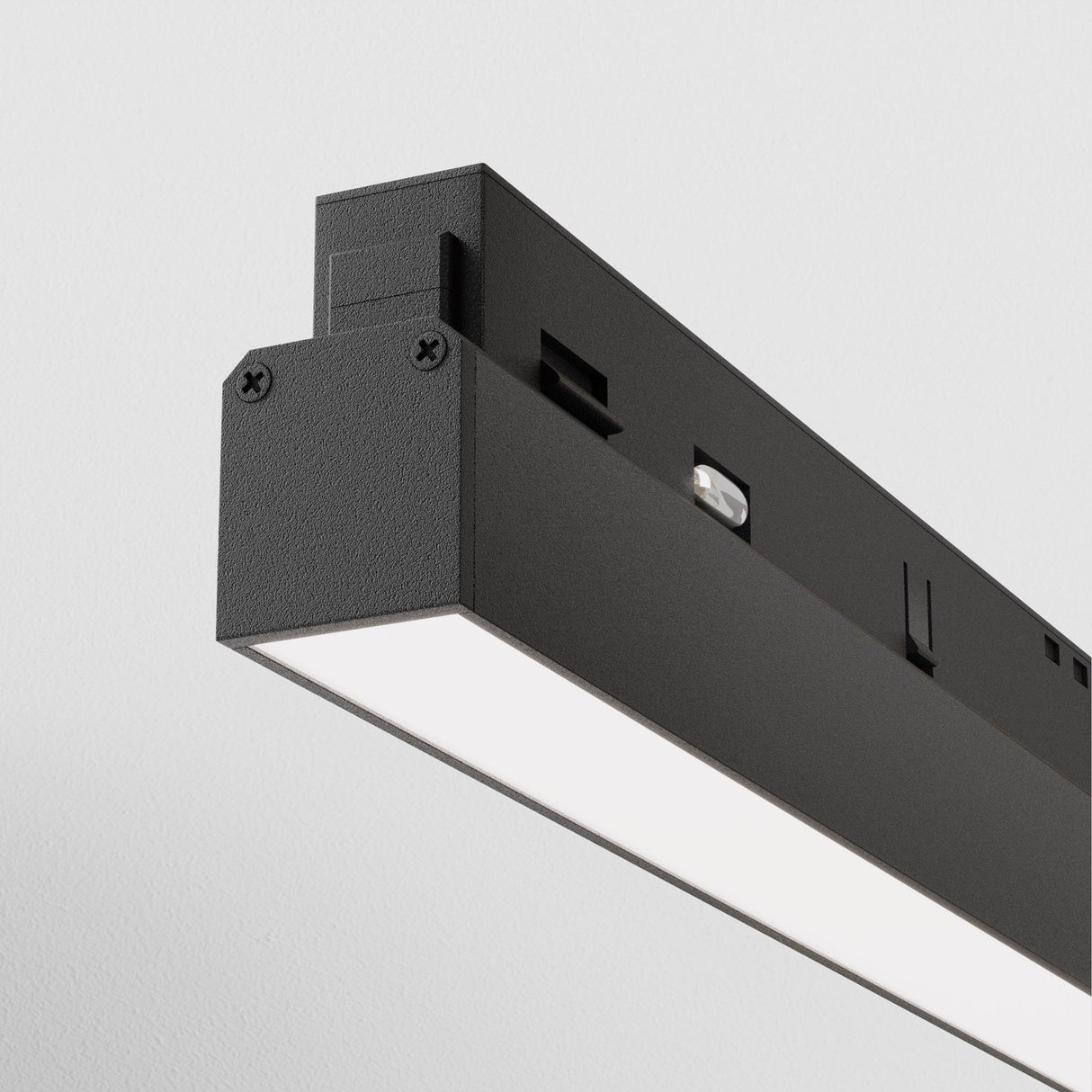 A close-up of the Basis DALI CCT LED Dimmable Linear Track Light for Magnetic Exility shows its minimalist, rectangular black design with a flat white-lit surface. This 24W smart light (2700-6000K) is mounted on a plain white ceiling, offering sleek modern lighting control.