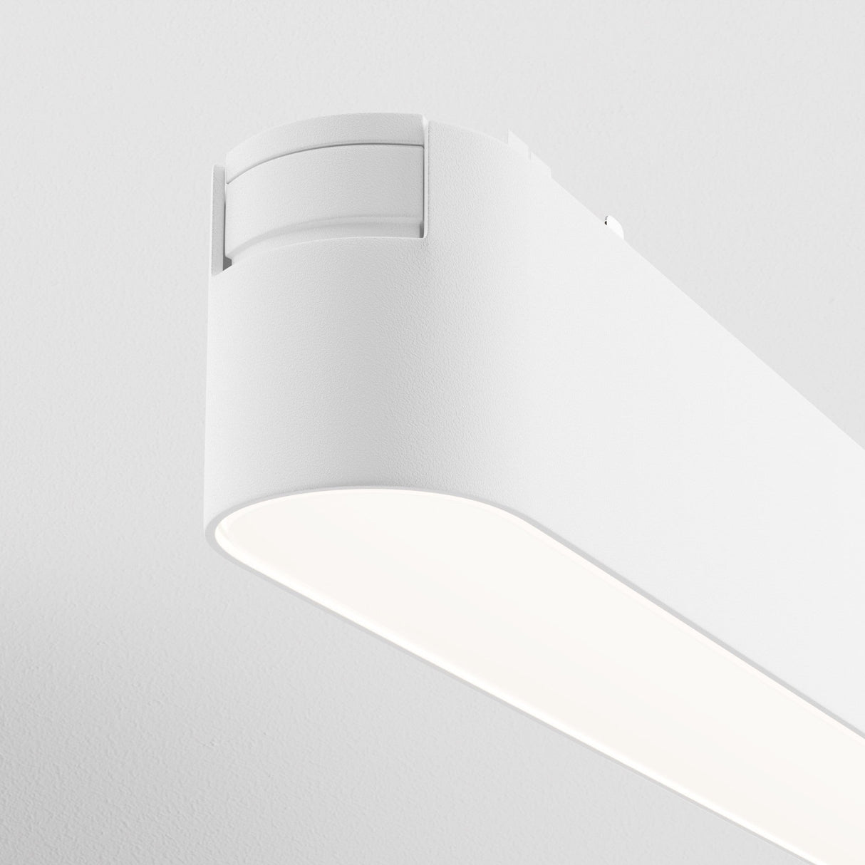 A close-up of the sleek Basis LED Linear Track Light for Magnetic Tracks Radity in white, featuring a modern design with rounded edges. Mounted against a plain white ceiling, its 12W power and 4000K temperature are ideal for minimalist contemporary interiors.