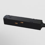 Close-up of the S35 Track Corner Power Connector - Black, featuring two rectangular sockets against a white background. Inscriptions adorn its surface, and a cable extends out of frame to the right.