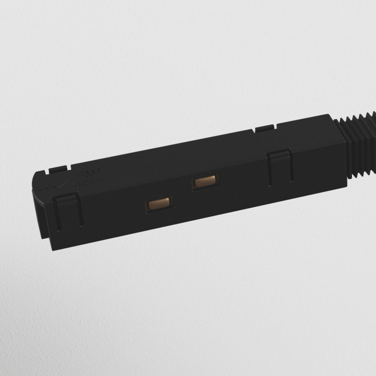 Close-up of the black S35 Track Straight Power Connector, rectangular with two metal contacts visible on one side, designed for uninterrupted power connection. It is connected to a corrugated cable against a white backdrop, perfect for magnetic track lighting systems.