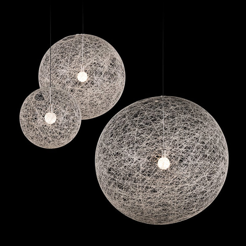 A trio of Sporadic Suspension Lights - White, showcasing textured globes crafted from intricate woven strands, are set against a black background. The differing sizes of the lights enhance the visual dynamics of the arrangement. Each piece casts a soft, warm glow that exudes contemporary elegance.