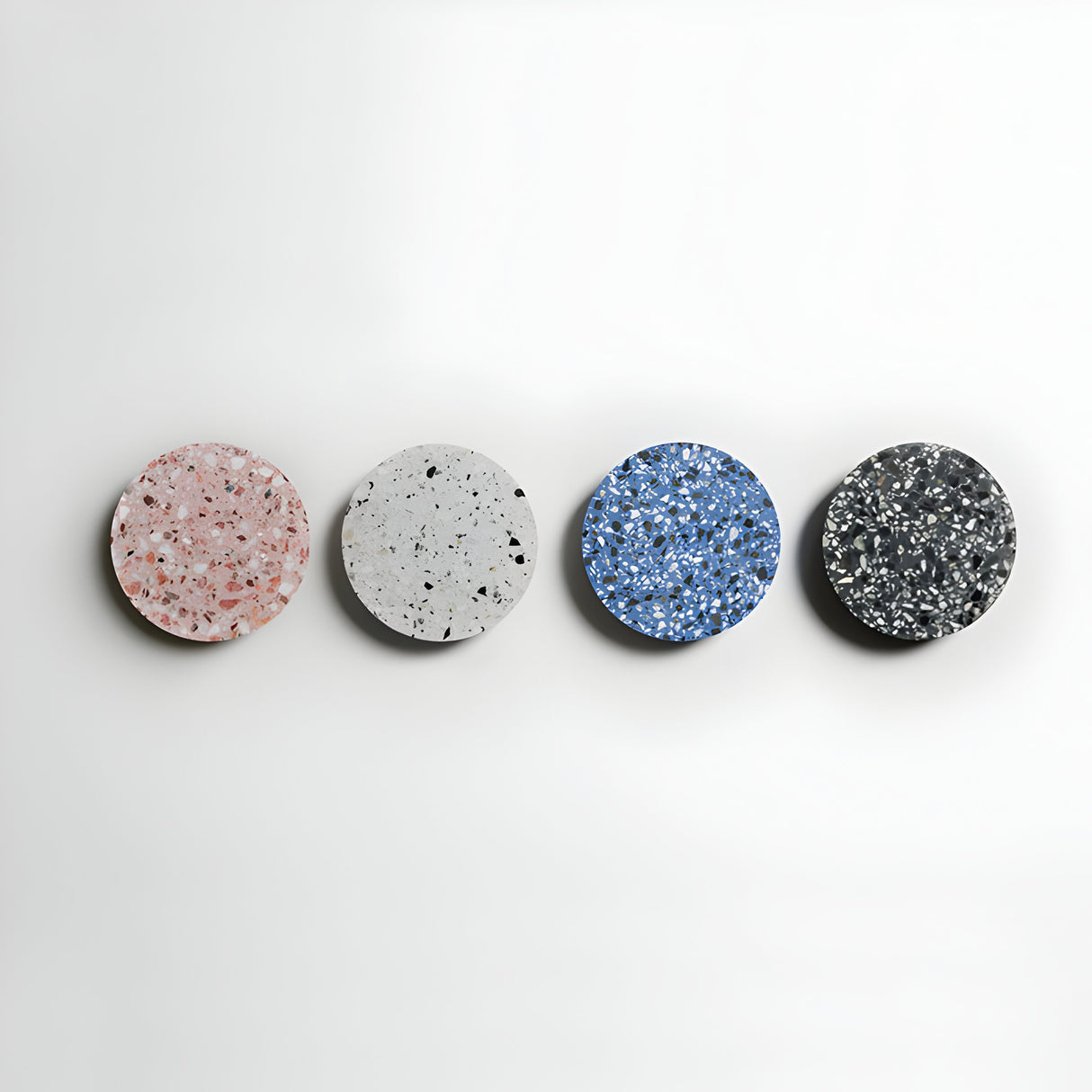 Four Pin LED Wall Lights are displayed in a row against a white background, showcasing modern minimalism. Each light features distinctive designs in pink, white, blue, and black, creating an ambient halo of color patterns.