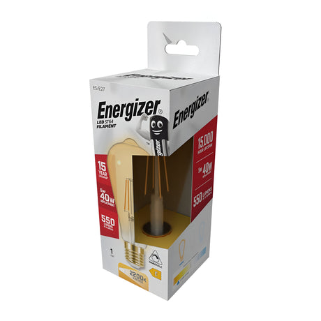 The box for the rectangular Energizer 5W Dimmable LED ST64 Gold Filament Bulb features an illustration of a yellow candle-style bulb and highlights its warm white hue. It boasts a 15,000-hour lifespan, provides light equivalent to 40 watts, and delivers a brightness of 550 lumens, perfect for creating ambient lighting.