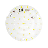 The PowerMaster 9.5W LED Emergency Bulkhead Gear Tray - CCT Adjustable showcases a circular design with small yellow LED chips on a white base, ensuring flicker-free performance and consistent illumination through centrally placed electronic components.