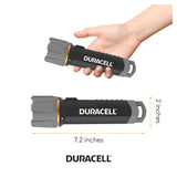 A hand holds a black and gray Duracell Floating LED Flashlight 200 Lumen from the 6-pack, with another identical water-resistant flashlight below, each measuring 7.2 inches in length and 2 inches in width. The Duracell logo is displayed at the bottom.