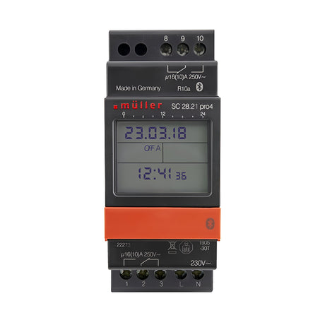 A digital timer switch, model Standard Bluetooth 2 Module 2 Channel 7 Day Time Switch, is encased in gray with an orange button and a display screen showing the date 23.03.18 and time 12:41. It offers daily and weekly programming capabilities, includes various electrical connectors and markings, and is made in Germany by Müller.