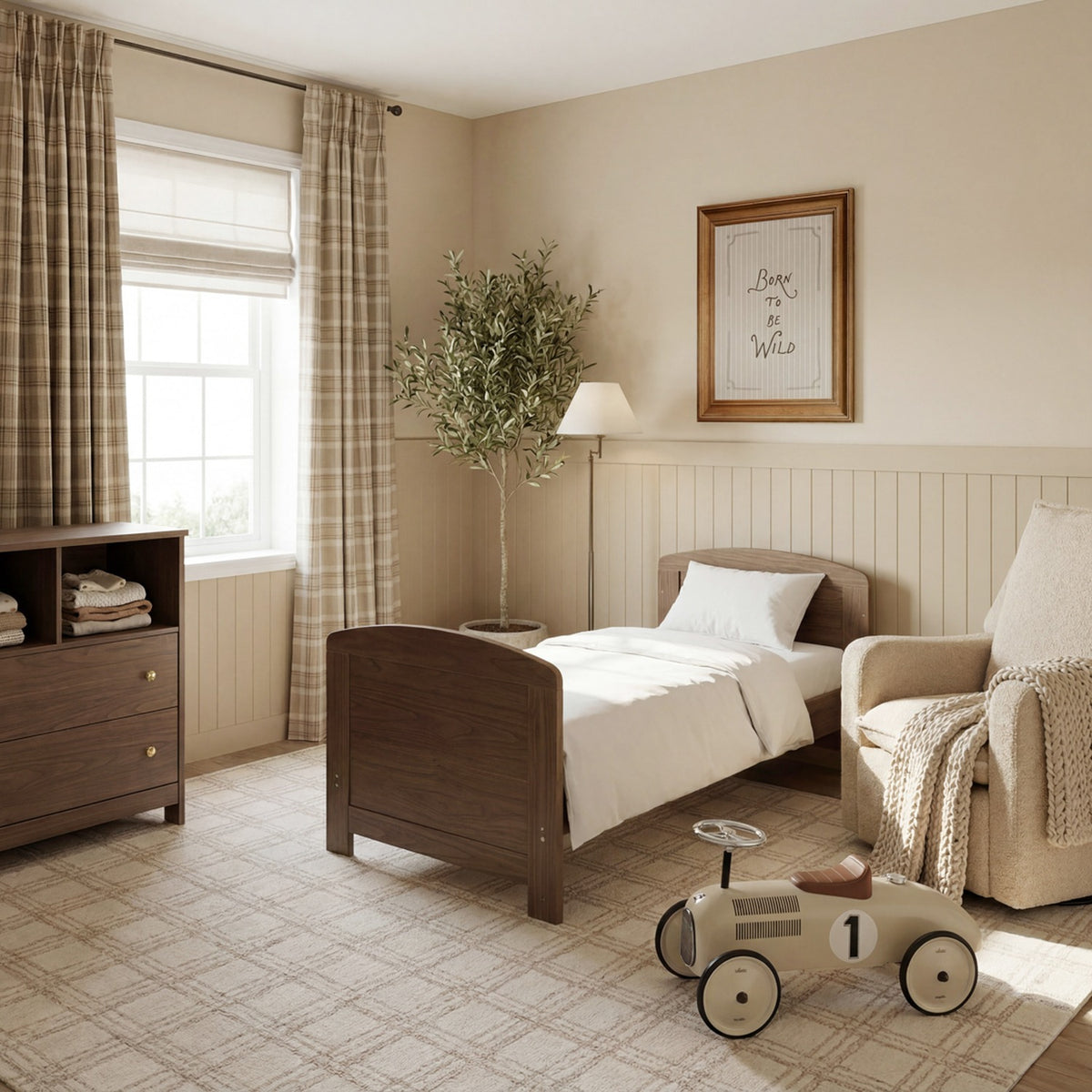 Seeker Convertible Cot Bed in Drift, a brown oak-effect wood toddler bed with curved headboard, shown made up with white bedding in a neutral nursery setting.
