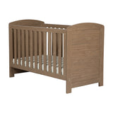 Seeker Convertible Cot Bed in Drift, an MDF cot bed with an oak-effect wood finish, slatted sides, arched end panels, and a mattress base, shown on a plain white background.