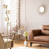 Cosmic 4 light floor lamp in black and brass finish, shown in a room setting