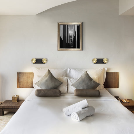 Lens 2 light wall light in black and brass finish, shown in a room setting