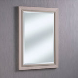 A beige, textured frame surrounds the chic Alaris Rectangle Wall Mirror - White on a light gray wall with subtle vertical patterns. This minimalist modern accent reflects soft, diffused light, enhancing the serene ambiance of contemporary interiors.