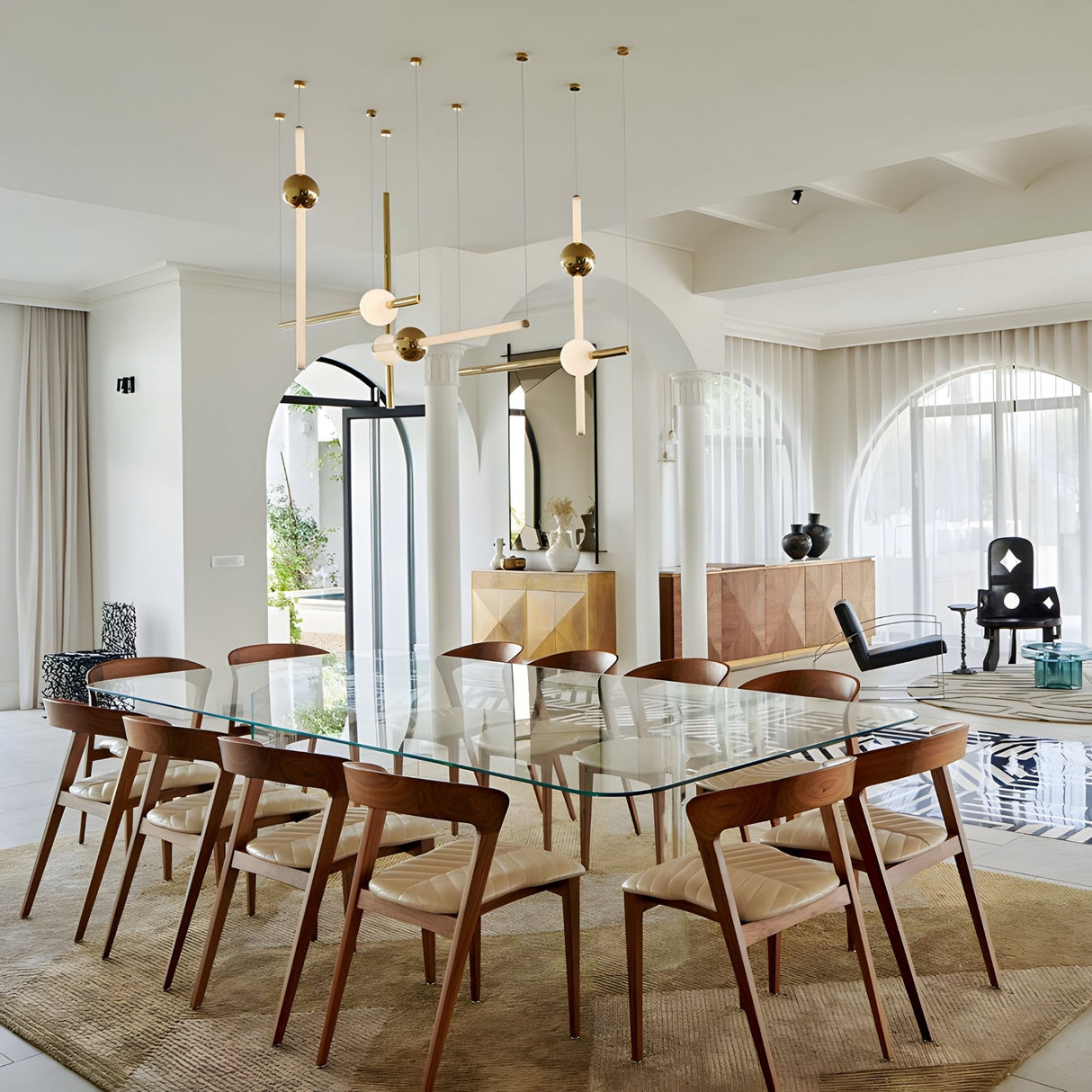 Modern dining room with a glass table, ten wooden chairs, Sottile LED Combination Suspension Light - Gold, large windows with sheer curtains, and decorative vases and artwork on sideboards and shelves for contemporary luxury.