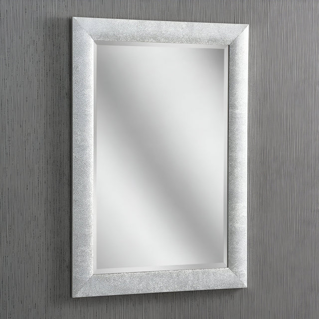 The Stardust Rectangle Wall Mirror - Silver, with its textured silver frame, adorns a vertically striped gray wall, exuding modern elegance. Its reflective surface displays no objects, creating a clean and minimalist aesthetic.