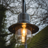 Aluminium teardrop lantern head in black, IP44 rated, mounted on an outdoor post with a lit E27 bulb visible through the clear glass shade.