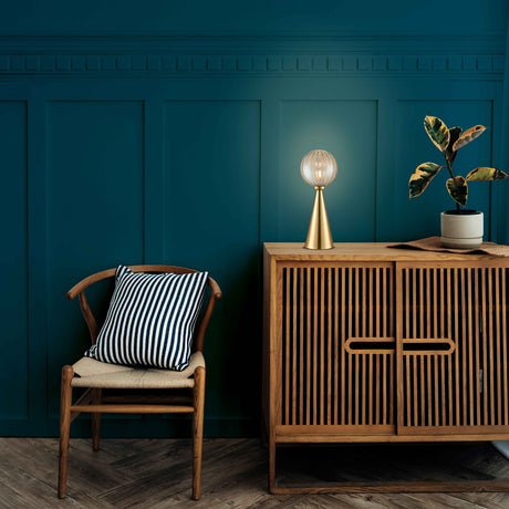 Quasar table lamp in brass finish, shown in a room setting