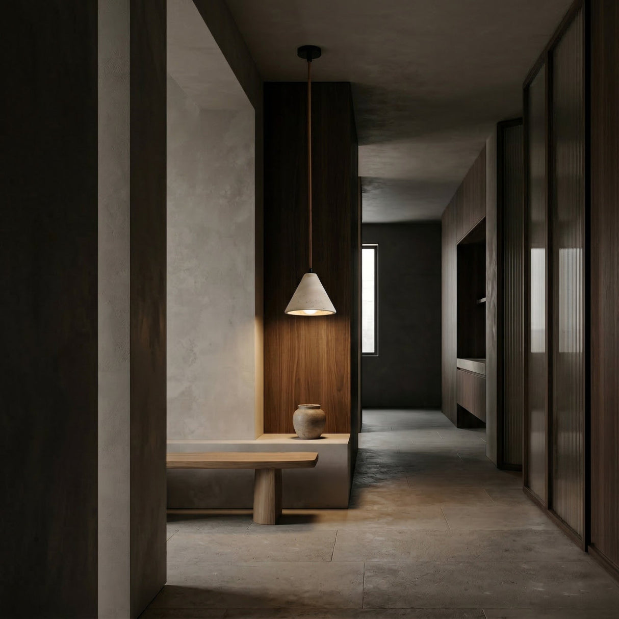 Minimalist hallway with muted tones, featuring a wooden bench, ceramic vase, and wood-paneled walls. Natural light streams through a window, highlighting the Sorella 1 Light Wide Cone Travertine Single Pendant Light in light beige.