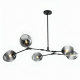 The Tree 5 Light Suspension - Black features five arms with smoky glass globe shades on a matte black rod, showcasing exposed bulbs for a modern, industrial touch and contemporary elegance.