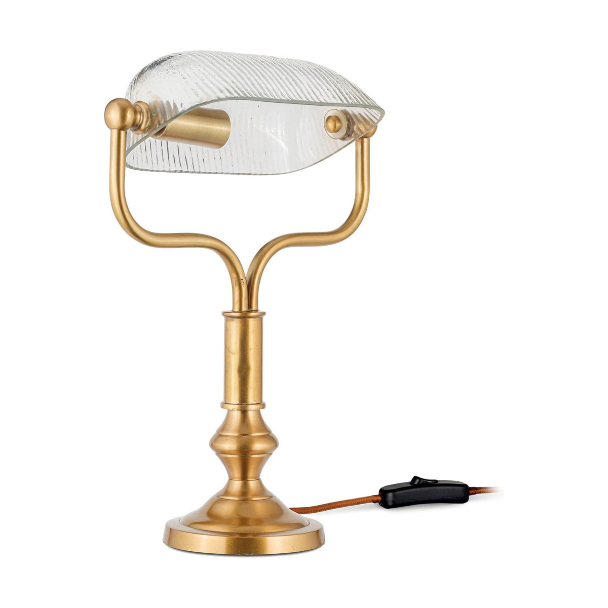 Ulani Vintage Desk Lamp in antique brass with a ribbed clear glass banker's shade on a twin stem yoke and stepped round base, shown with a brown cord and inline switch on a white background.