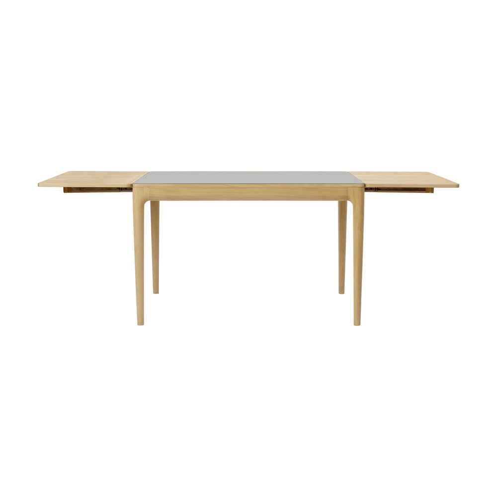 Heart'n'Soul 120 extendable oak dining table with cloud grey tabletop inset, tapered wooden legs, and pull-out extension leaves, shown on a plain white background.
