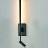 Luca Black LED Wall Light with slim upright bar, rectangular wall plate, and adjustable reading spotlight, mounted on a light grey wall with warm uplight glow.