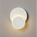Crescent White Small LED Wall Light with two overlapping circular discs in matte white, the smaller disc glowing with warm light against a plain grey background.