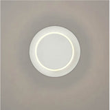 Crescent White LED Wall Light with a round matt white disc design and a soft glowing inner ring, mounted on a plain neutral wall.