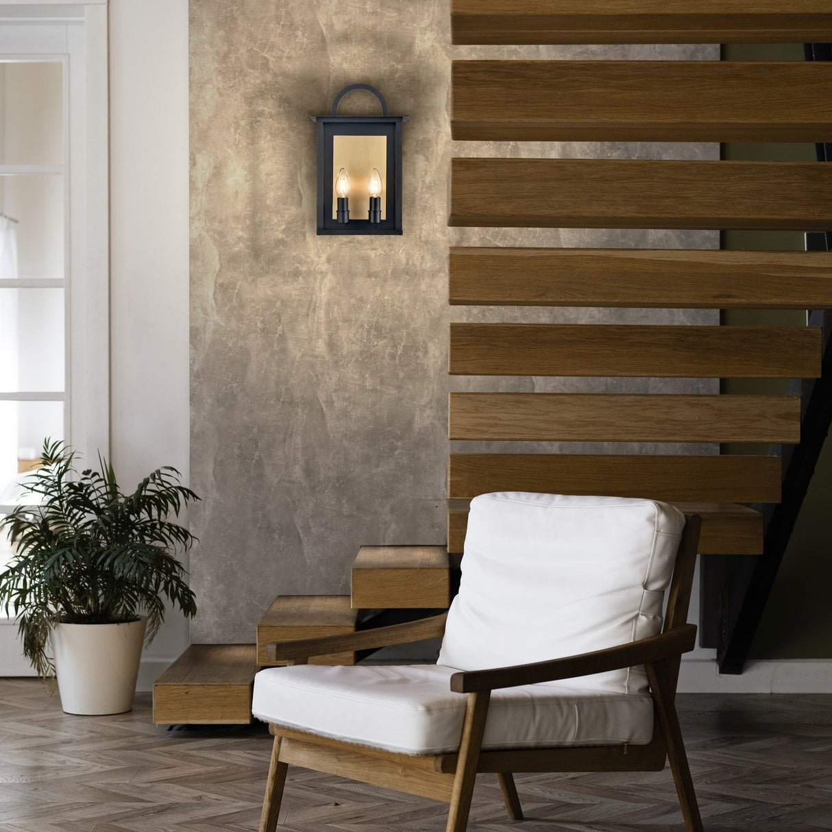 Nightingale 2 light exterior wall light in black and brass finish, shown in a garden setting