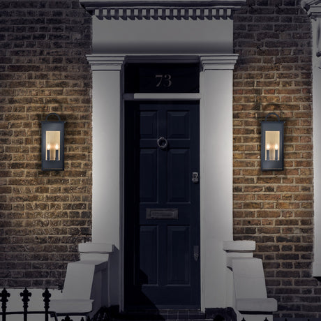 Nightingale 2 light exterior wall light in black and brass finish, shown in a garden setting