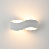 Infinity Matt White LED Wall Light with a curved metal S-shaped body, uplighting and downlighting softly against a plain white wall.
