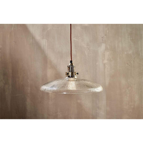 Zowie Large Glass Pendant Light in antique brass, featuring a wide ribbed glass dish shade on a rust-coloured braided cord, shown against a neutral wall.