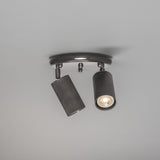 Adare Brass 2 Light Ceiling Spotlight with round ceiling plate, central ball finial, and two reeded cylindrical dark metal heads on adjustable arms, shown against a plain light grey background.