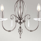 Presenting the Aegean 3 Light Chandelier - Polished Nickel, a contemporary lighting fixture showcasing a central ornate design and three gracefully curved arms, each holding candle-shaped bulbs adorned with crystal accents. Its elegant finish in polished nickel is beautifully complemented by a neutral light gray backdrop to enhance its timeless appeal.