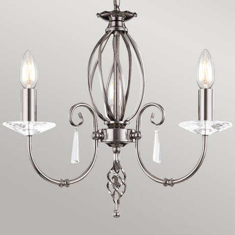 The Aegean 5 Light Chandelier in polished nickel showcases hand-forged scrolls and crystal accents, complete with two candle-shaped light bulbs set against a gray backdrop.