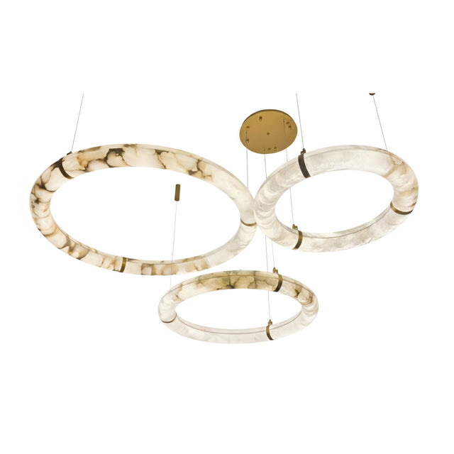 The Aureon LED Triple Ring Alabaster Circular Suspension Light – Soft White features three large marbled white and brown rings, suspended at varying heights from thin cables on a round gold ceiling mount for a striking modern chandelier look.