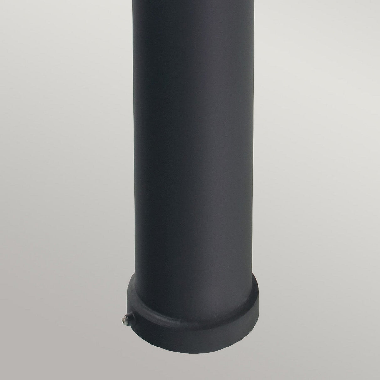 A close-up view of a black cylindrical pole with an IP65 rating against a neutral background. The pole, resembling the Alta 1 Light Large Bollard - Black, has a smooth surface and a small protrusion near the base, making it suitable for outdoor lighting installations.