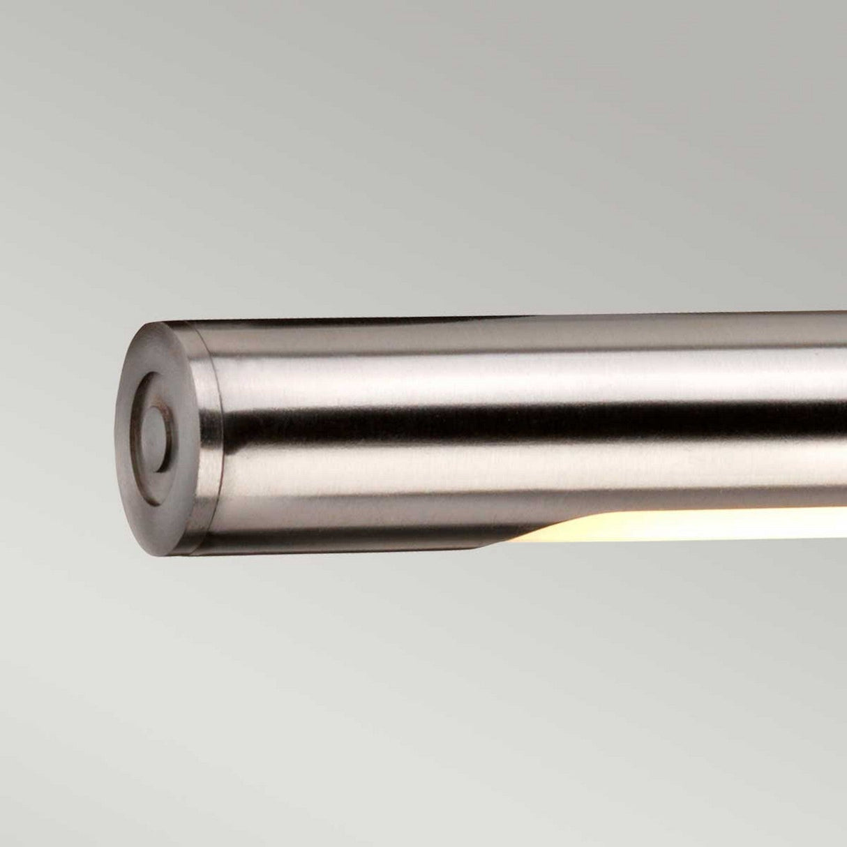 Close-up of the Alton 1 Light Large LED Picture Light in brushed nickel, showcasing its sleek, cylindrical form and minimalist design. Mounted on a pale gray background, it highlights a brushed metal finish with a subtle glow from the bottom side, ideal for enhancing art displays.