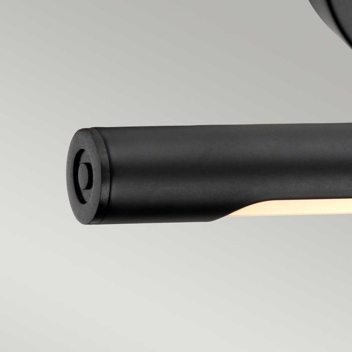 Featuring a close-up of the Alton 1 Light Small LED Picture Light in black, this modern cylindrical wall fixture stands out against a light gray background. Its sleek design and recessed light source make it ideal for illuminating artwork in compact spaces.