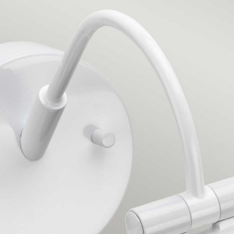 Close-up of the Alton 1 Light Small LED Picture Light in white, featuring a modern, adjustable arm. The image highlights the lamp's curved arm and cylindrical light fixture attached to a circular wall mount. This sleek, energy-efficient design stands out against a light gray background, exuding elegance and minimalism.