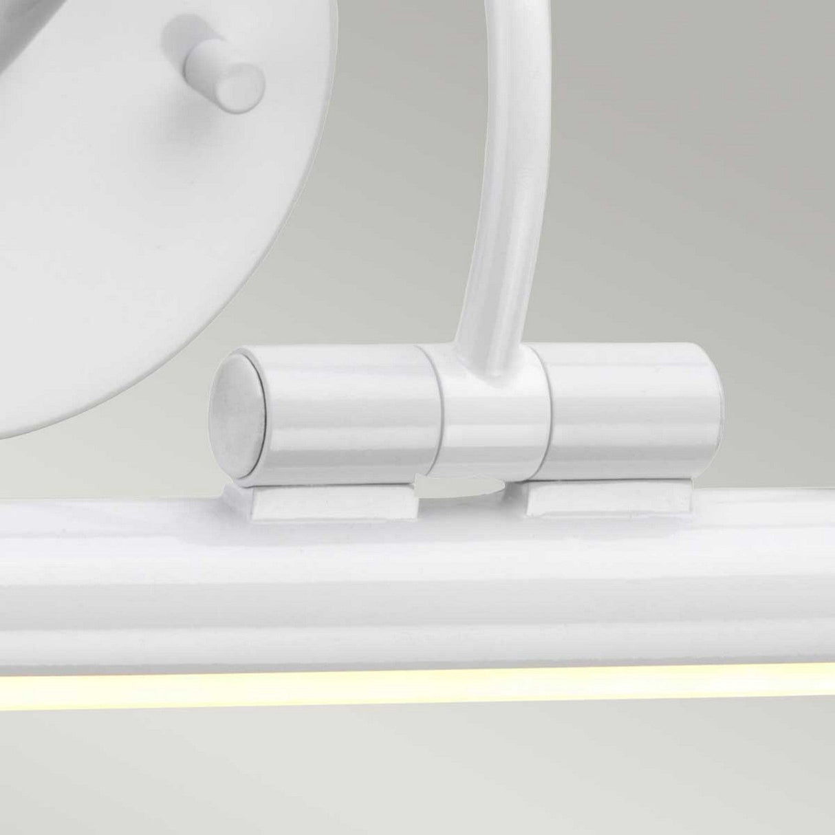 Close-up of the Alton 1 Light Small LED Picture Light in white, featuring a cylindrical fixture and round mount against a light gray background. This energy-efficient lamp includes an adjustable, curved arm connecting the mount and the light bar.