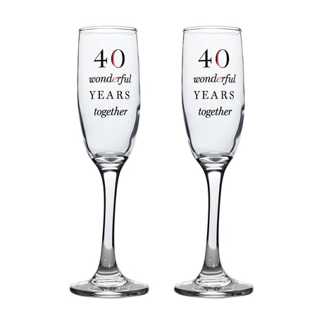 Set of two clear glass champagne flutes with tall narrow bowls, slim stems and round feet, each printed with "40 wonderful YEARS together" in black and red lettering, on a plain white background.