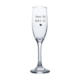 Clear glass champagne flute with tall slender bowl and long stem, printed "beautiful BRIDE" in silver script and capitals above a small heart, shown on a plain white background.