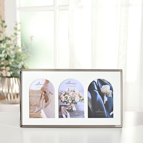 Triple metal photo frame with arch mounts, 6 x 4in, in a shiny silver finish with a cream mount, displaying three wedding photos on a table by a window.