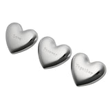 Three silverplated heart-shaped ornaments with a mirror-bright finish, each engraved with "Love", "Forever" and "Together" in typewriter lettering, arranged on a white background.