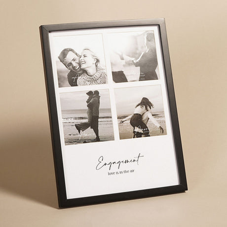 Black wooden multi-aperture photo frame with four square openings on a white mount, "Engagement, love is in the air" script below, shown against a neutral background.
